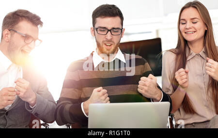 Tre dipendenti eccitati ricevendo buone notizie insieme sulla linea Foto Stock