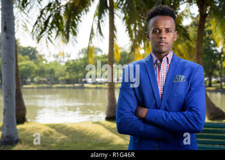 Bel giovane imprenditore africano di relax presso il parco in Bangk Foto Stock