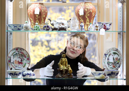 Casa d'Aste assistant Jaine Heggie prende uno sguardo più da vicino a una dinastia Ming gilt-gruppo bronzeo di Guanyin e Sudhana e altri elementi che è visualizzato a Bonhams, Edimburgo prima di esso è offerto in asta come parte di un'arte asiatica vendita il prossimo giovedì. Foto Stock