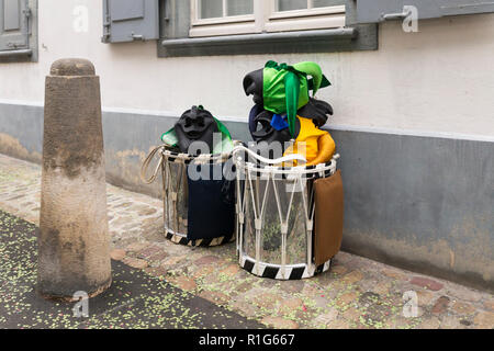 Il Carnevale di Basilea 2018. Nadelberg, Basilea, Svizzera - Febbraio 19th, 2018. Close-up di un mucchio di maschere di carnevale e rullante su strada Foto Stock