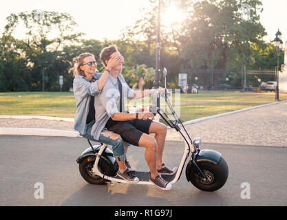 Bella giovane coppia felice la guida elettrica bici Foto Stock