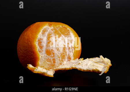 Mezza sbucciata mandarin su uno sfondo nero close-up 2018 Foto Stock