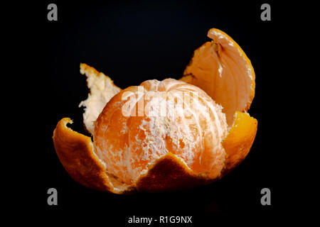 Mezza sbucciata mandarin su uno sfondo nero close-up 2018 Foto Stock