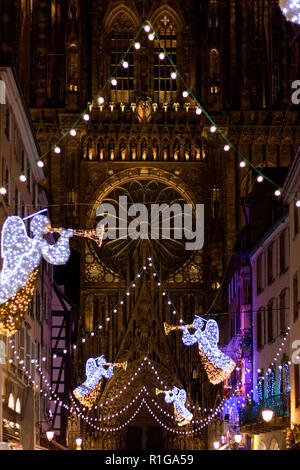 Festa di Natale luci e decorazioni con sfondo sfocato di fronte Chathedrale Notre Dame a Rue Merciere a Strasburgo - capitale di Christm Foto Stock