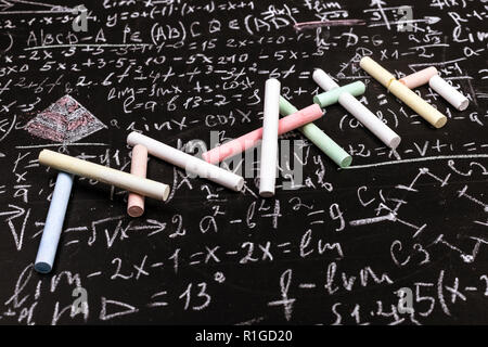 La scrittura di math dal gesso su background scientifico di formule e calcoli in fisica e matematica. Foto Stock