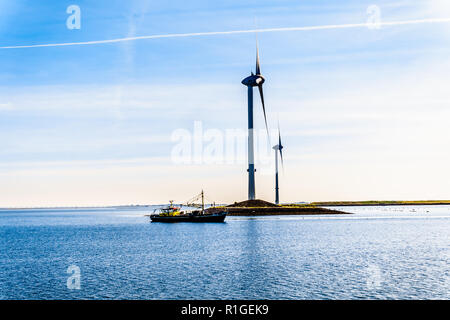 Barca da pesca e delle turbine a vento all'ingresso Oosterschelde al Neeltje-reimerswaal Jans isola al Delta opere Mareggiata barriera in Zeeland, Olanda Foto Stock