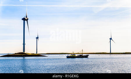 Barca da pesca e delle turbine a vento all'ingresso Oosterschelde al Neeltje-reimerswaal Jans isola al Delta opere Mareggiata barriera in Zeeland, Olanda Foto Stock