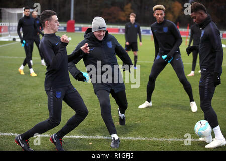 Inghilterra U21's Phil Foden (sinistra) viene affrontato dal manager Aidy Boothroyd come Demarai grigio (destra) si affaccia su durante la sessione di formazione presso il St George's Park, Burton. Foto Stock