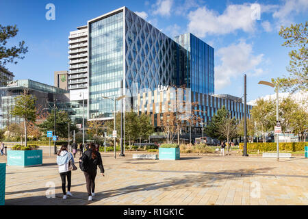 2 Novembre 2018: Salford Quays, Manchester, Regno Unito - ITV di edifici su una soleggiata giornata autunnale, cielo blu chiaro, due giovani donne a camminare verso la costruzione. Foto Stock