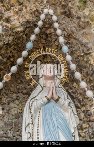 Replica di una statua della Vergine di Lourdes a pregare su una roccia Foto Stock