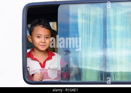 Phnom Penh Cambogia - 30 dicembre 2018: un grazioso piccolo ragazzo che guarda fuori dalla finestra della sua auto in strada di Phnom Penh, capitale cambogiana Foto Stock