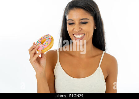 Ritratto di estremamente felice latino bella giovane donna di mangiare una deliziosa ciambelle godendo con piacere in trattatevi bene e dimenticare di Foto Stock