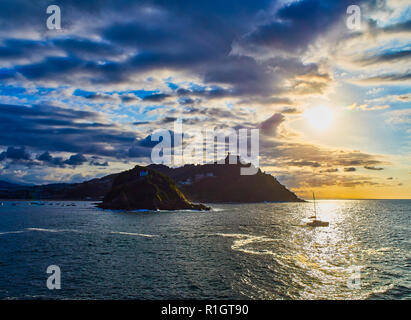 Il sole tramonta dietro la Santa Clara Island e il Monte Igueldo Mount, gli elementi principali della baia della Concha. Vista dal Paseo Nuevo. San Sebastian Foto Stock