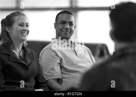 Persone sedersi e parlare in un aeroporto Foto Stock