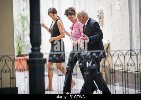 Due metà adulto business donna Imparare una danza da un senior collega di sesso maschile in un balcone. Foto Stock