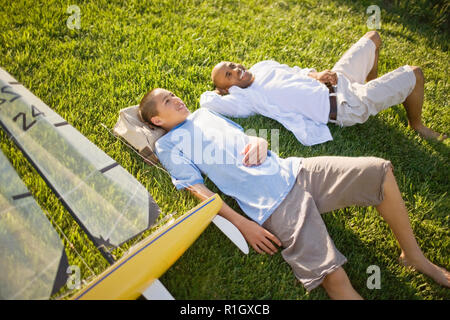 Padre e figlio sdraiati sull'erba Foto Stock