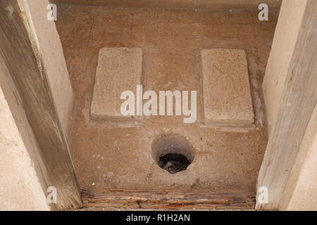 Foro nel pavimento, esegui uno squat wc, Al Alawi House, situata sul sentiero di perla, Muharraq, Regno del Bahrein Foto Stock