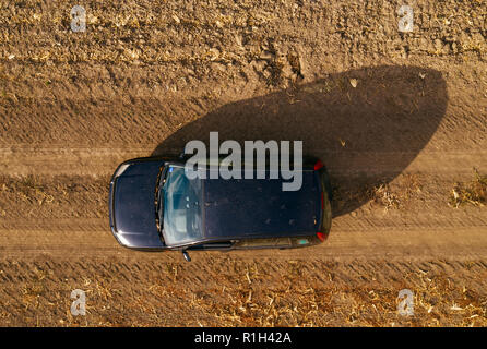 Vista aerea del nero auto sulla strada sterrata attraverso la campagna, vista dall'alto di off-road durante la guida del veicolo da fuco pov Foto Stock