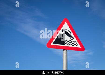Codice della strada triangolo rosso cartello stradale nel Regno Unito gli automobilisti di avvertimento circa il pericolo di una banchina o banca di fiume. Foto Stock
