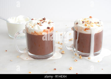 Cioccolata calda la torta con panna montata e nocciole tritate Foto Stock
