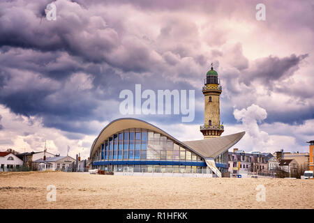 Teepott e faro sotto le nuvole drammatico a Warnemünde. Foto Stock