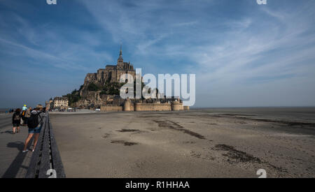 Vista del paesaggio di Mont Saint Michel durante la bassa marea e vasto velme con turisti fotografare. Foto Stock