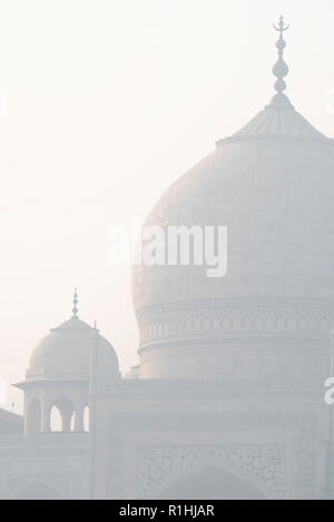 I graziosi archi di cupole del magnifico Taj Mahal la meraviglia del mondo e l'orgoglio di India in marmo bianco in inverno mattina haze Foto Stock