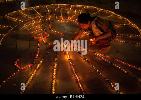 Una donna accendendo candele in Mahamuni Image tempio, Mandalay Myanmar. Foto Stock