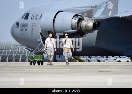 North Carolina aria guardie nazionali di prepararsi per una U.S. Esercito Black Hawk a terra e organi di presa da 145disponibilità logistica Squadron (LRS) a La Carolina del Nord (N.C.) Air National Guard Base, l'Aeroporto Internazionale Charlotte Douglas, Sett. 20, 2018. La 145LRS i membri sono diretti a Tarboro, N.C. per passare fuori i membri che lavorano i soccorsi dall uragano Firenze. Foto Stock