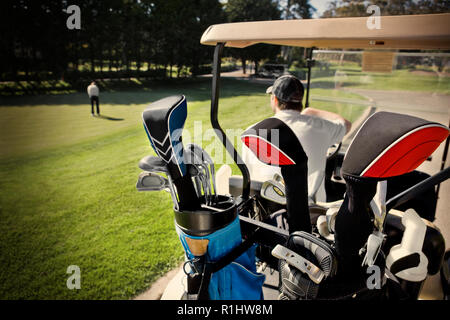 Club di golf all'interno di una sacca da golf nella parte posteriore di un carrello da golf in un campo da golf. Foto Stock