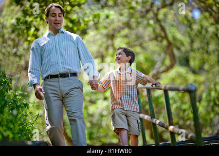 Felice di padre e figlio a piedi giù per le scale in un parco. Foto Stock