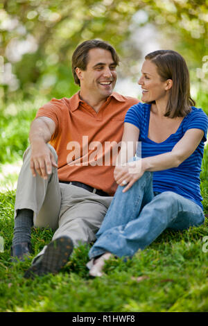 Felice metà adulto giovane seduti insieme in un parco. Foto Stock