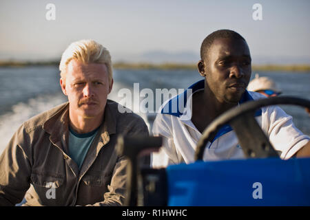 Metà di uomo adulto seduto con un giovane uomo adulto su una barca. Foto Stock