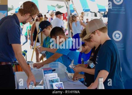 Alex Hayes con la NHHS la comunicazione e la divulgazione della divisione, staffs uno stand durante il NAS Oceana Air Show. I membri del personale della storia navale e Patrimonio il comando e il museo personale congiunto in una cabina per fornire camminare fino a stelo (Scienza Tecnologia e Ingegneria Matematica) istruzione al quinto grado gli studenti nella città di Virginia Beach. Altri espositori presenti sono state la US Navy custodi del mare, Flotta US il comando delle forze e la Tidewater Community College Robotics Team. Foto Stock