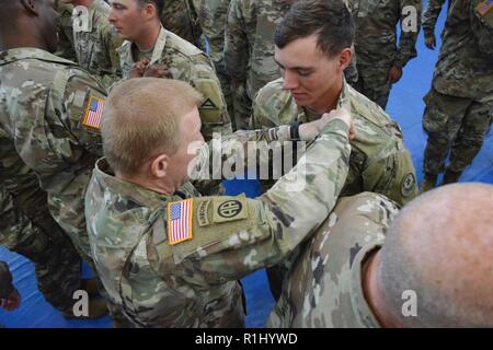 Il 2° reggimento di cavalleria comandante U.S. Esercito Col. Thomas M. perni di Hough l'air assault badge su uno dei suoi soldati durante un assalto dell'aria corso cerimonia di laurea al settimo Esercito di formazione Torre di Comando caserma, Grafenwoehr, Germania, Sett. 21, 2018. Il corso è stato condotto da un esercito di guardia nazionale mobile team di formazione da Fort Benning, Ga. Foto Stock