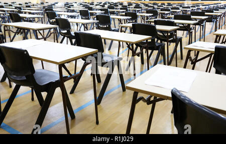 Vista di una grande sala esame sala esame e scrivanie tavoli allineati in file pronto per gli studenti di una scuola superiore di venire e sedersi i loro esami carta per prove Foto Stock