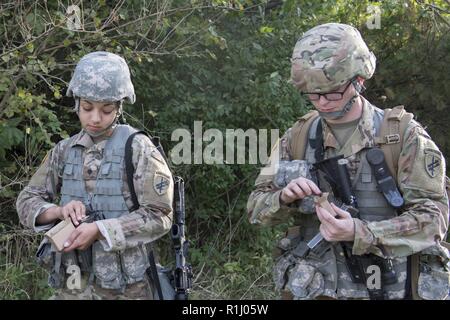 Da sinistra, U.S. Army Spc. Kristen Bowman e PFC. Jeff Hall, entrambi 316Operazioni psicologiche Company PSYOP specialisti, caricare le munizioni prima di reagire al contatto esercizio durante un esercito guerriero compito della concorrenza a Grissom riserva d'aria di base, Indiana, Sett. 21, 2018. Durante la competizione, soldati e aviatori hanno lavorato insieme al comune di prova le abilità di combattimento in: Hand Grenade operations, armi di competenze di lettura mappa, passando sotto il fuoco, escalation della violenza, di valutazione e di evacuazione feriti e l'uso di equipaggiamento protettivo. Foto Stock