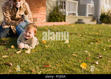 Padre giocando con il figlio sul prato anteriore. Foto Stock