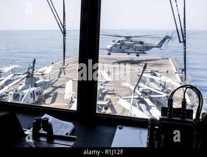 Un U.S. Marine Corps CH-53E mare Dragon elicottero, attaccato al mezzo marino Tiltrotor Squadron (VMM) 166 rinforzato, lancia dal ponte di volo di trasporto anfibio dock nave USS ancoraggio LPD (23) durante una regolare distribuzione pianificata di Essex anfibio gruppo pronto (ARG) e xiii Marine Expeditionary Unit (MEU) nel Golfo di Aden, Sett. 20, 2018. L'Essex ARG/XIII MEU è un letale, flessibile e persistente Navy-Marine Corps team distribuito negli Stati Uniti Quinta Flotta area di operazioni a sostegno di operazioni navali per garantire stabilità marittimo e la sicurezza nella regione centrale, connes Foto Stock