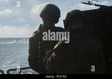 Marinaio Trevor Brumley, sinistra, mani munizioni per Lance Cpl. William Daniels durante la formazione gunnery a bordo dell'assalto anfibio nave USS Wasp (LHD 1), in corso nel Mare della Cina del Sud, Sett. 24, 2018. Brumley è un ospedale corpsman e Daniels è una luce veicolo blindato crewman, sia con armi Company, Battaglione Team di atterraggio, 2° Battaglione, 5 Marines. Durante la formazione, i Marines in scena LAVs in cima il Wasp del ponte di volo per affinare le loro capacità gunnery di agire come la sicurezza della nave. Il trentunesimo MEU, il Marine Corps' solo in modo continuo distribuita MEU, fornisce una forza flessibile ready t Foto Stock