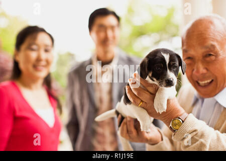 Il vecchio uomo riceve un cucciolo. Foto Stock