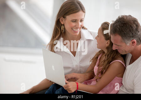 Middle-Aged matura e la loro figlia sorridere mentre si sta guardando un lap top. Foto Stock