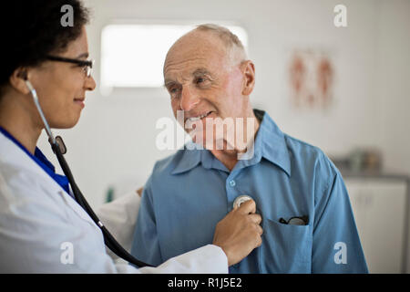 Dottore in ascolto a un senior del paziente. heartbeat Foto Stock