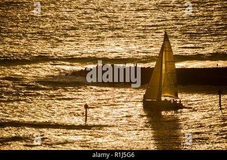 Barca a vela intitolato al tramonto con Magic Island, Oahu, Hawaii in background Foto Stock