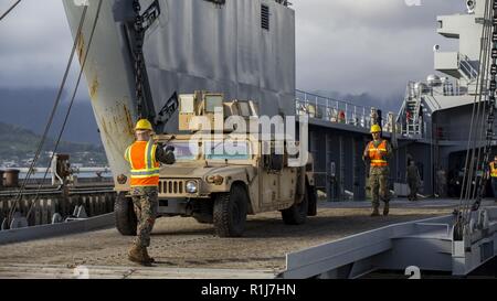 Stati Uniti Marines con il combattimento il battaglione della logistica 3 (CLB-3) caricare un elevata mobilità multiuso di veicolo su ruote (HMMWV) su navi di sostegno logistico (LSV) presso la Marina in Marine Corps base Hawaii, Kaneohe Bay, il 7 ottobre 2018. L'ingranaggio e attrezzature caricato sarà trasportato per la Big Island delle Hawaii per esercitare Bougainville II. Foto Stock