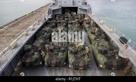 Stati Uniti Marines Corps assalto veicoli anfibi (AAV) assegnata al Combat Assault Company, 3° Reggimento Marine, terza divisione Marine vengono caricati su un navi di sostegno logistico (LSV) presso la Marina in Marine Corps base Hawaii, Kaneohe Bay, il 7 ottobre 2018. L'ingranaggio e attrezzature caricato sarà trasportato per la Big Island delle Hawaii per esercitare Bougainville II. Foto Stock