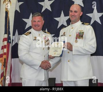 ANDERSEN AIR FORCE BASE, Guam (ott. 5, 2018) - elicottero mare ala di combattimento, U.S. Flotta del Pacifico, commodore Capt. Kevin Kennedy presenta il servizio meritevole medaglia da in uscita mare elicottero Combat Squadron 25 comandante della Cmdr. William Eastham durante la HSC-25 modifica del comando cerimonia in occasione della conferenza di sunrise center presso Andersen Air Force Base 5 ottobre. Durante la cerimonia, la Cmdr. Frank Loforti alleviato Eastham come comandante. Foto Stock