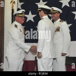 ANDERSEN AIR FORCE BASE, Guam (ott. 5, 2018) - USA Flotta del pacifico mare elicottero combattere ala commodore Capt. Kevin Kennedy si congratula con elicottero in arrivo mare squadrone di combattimento 25 comandante della Cmdr. Frank Loforti durante la HSC-25 modifica del comando cerimonia in occasione della conferenza di sunrise center presso Andersen Air Force Base 5 ottobre. Durante la cerimonia, Loforti alleviato la Cmdr. William Eastham come comandante. Foto Stock