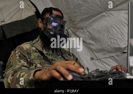 Stati Uniti Esercito il Mag. Jerry M. Cole, il piani di brigata capo assegnato alla 224th supporto brigata, California Army National Guard, indossa la M50 Servizio comune scopo generale maschera durante l'esecuzione dei suoi doveri durante Warfighter 19-1 a Camp Atterbury, Indiana, Ottobre 8, 2018. Cole indossato la sua maschera di protezione come parte di un warfighter esercitazione. Foto Stock