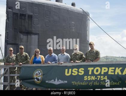 APRA HARBOR, Guam (ott. 09, 2018), a partire da sinistra, il cap. Jeffery Grimes, commander, Base Navale Guam, la Cmdr. Steven Tarr, comandante della Los Angeles-class attack submarine USS Topeka (SSN 754), il sig. de Yanger, il Sig. Albert Yanger e la Sig.ra Katherine Lee, i membri del personale per Guam congressista Madeline Z. Bordallo, STSCM (SS) Capo della barca (COB), Michael Wangen, Lt. La Cmdr. Emil Dinnocenzo, delegato di USS Topeka scattare una foto di gruppo sul ciglio, come essi arrivano per un tour in sottomarino il 9 ottobre. Topeka è uno dei quattro distribuita sottomarini homeported in Apra Harbor, Guam Foto Stock